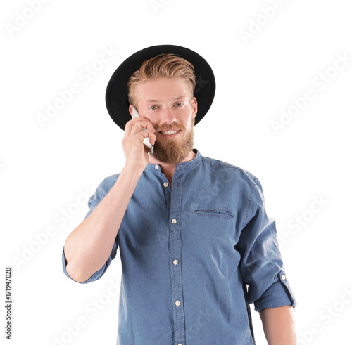 Young hipster man talking on phone against white background