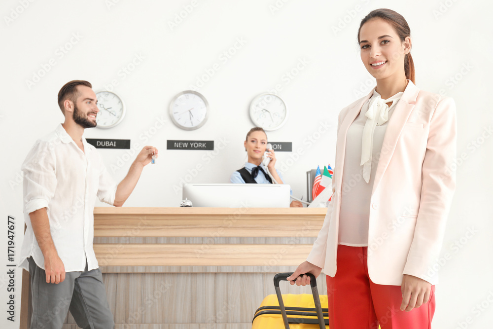 Obraz premium Young woman near reception counter in hotel
