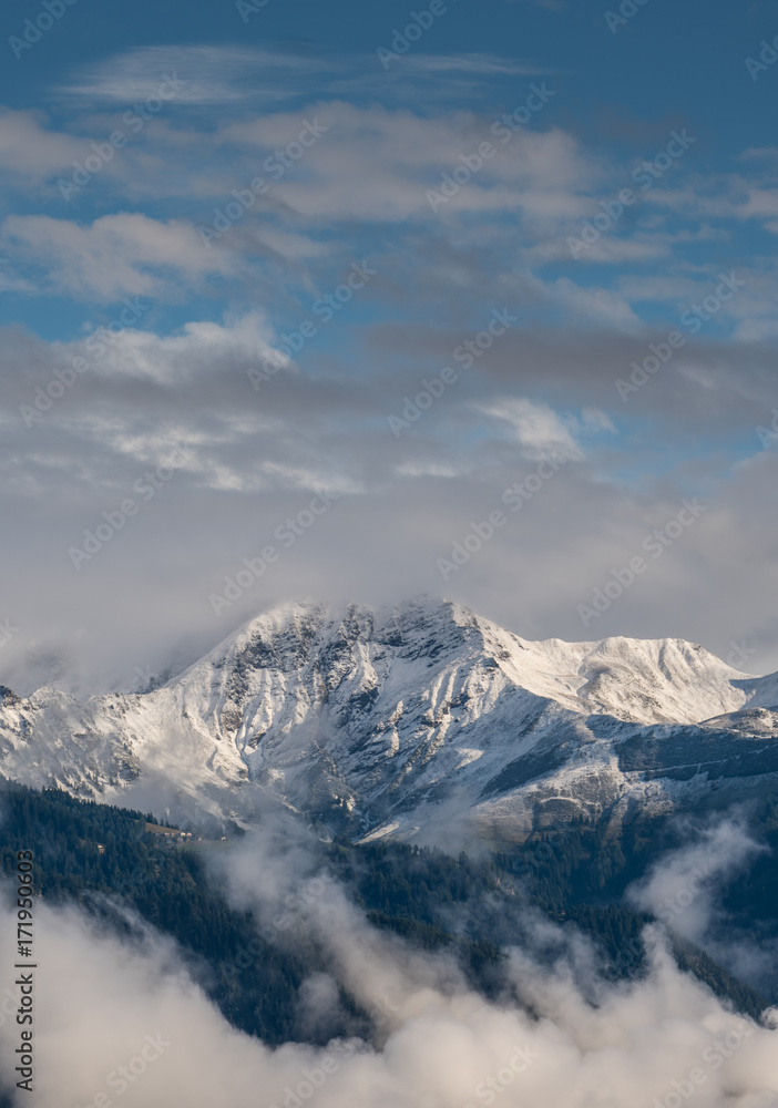 vertical view of mountain in the Swiss Alps after fresh snow fall with cloud cover in the foreground
