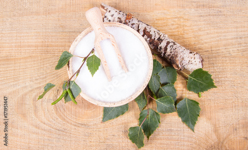 Xylitol - sugar substitute. Birch sugar on wooden background. photo