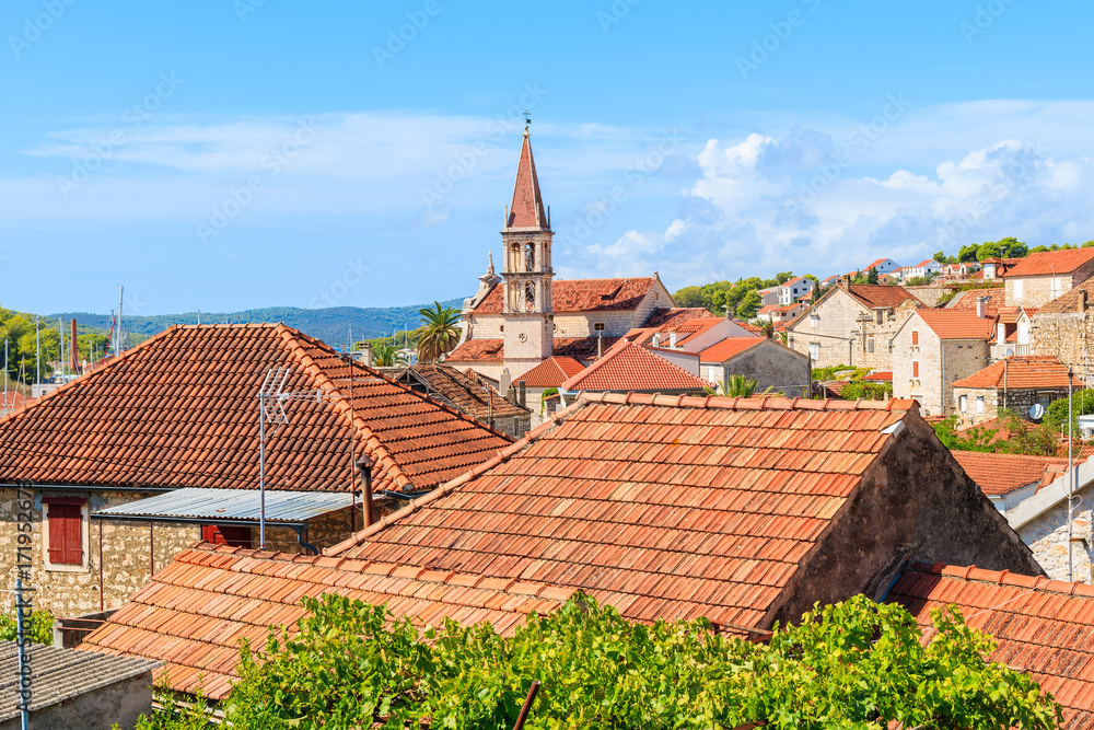 View of Milna town with orange tile roofs and beautiful church tower in center, Brac island, Croatia