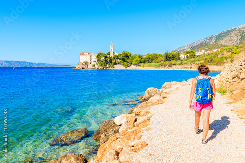 Young woman tourist walking on coastal path along sea to Dominican monastery in Bol town, Brac island, Croatia © pkazmierczak