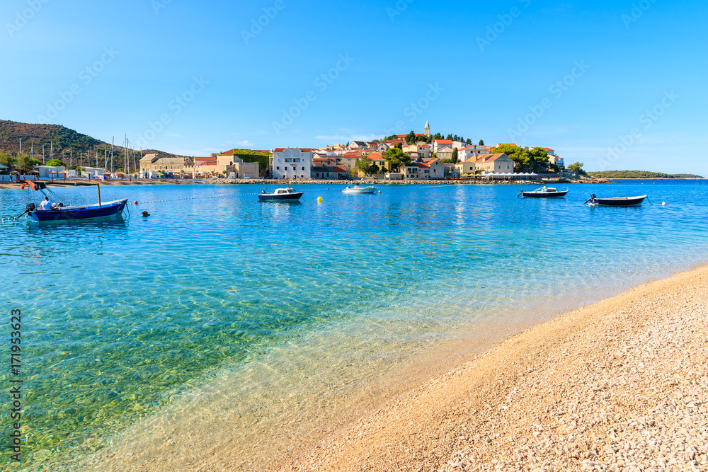 Pebble stone beach with crystal clear turquoise sea water in Primosten town, Dalmatia, Croatia