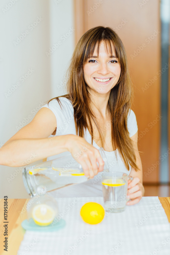 Drink water. Woman's hand pouring fresh pure water with pieces of lemon from pitcher into glass in the morning Health and diet concept. Healthy lifestyle. Healthcare and beauty. Hydratation. Drink water. Woman's hand pouring fresh pure water with pieces of lemon from pitcher into glass in the morning Health and diet concept. Healthy lifestyle. Healthcare and beauty. Hydratation.