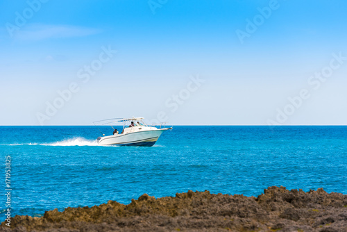 A white boat sails on the sea in Bayahibe, La Altagracia, Dominican Republic. Copy space for text.