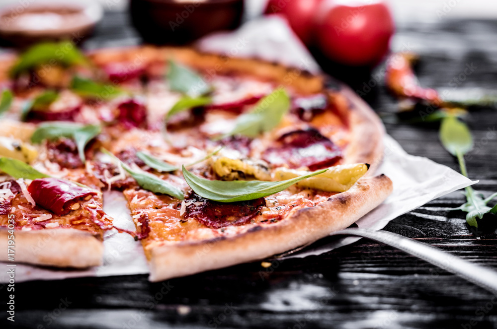 Delicious spicy pizza on wooden background