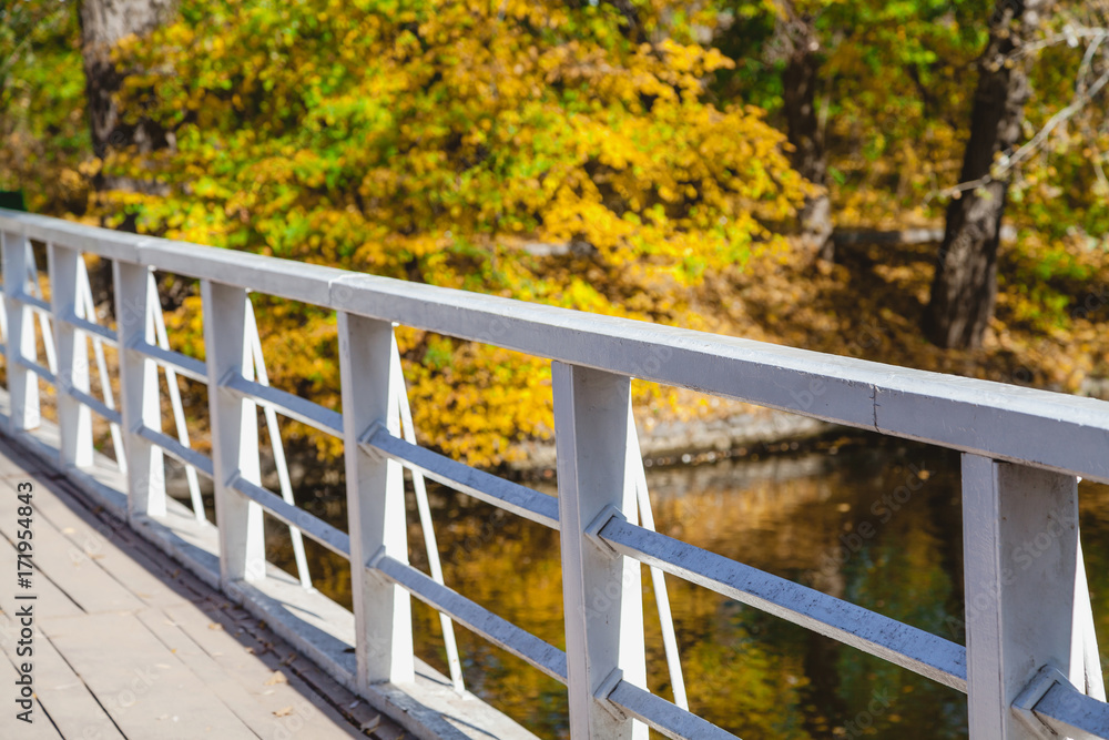 Wooden footbridge over the river a bright autumn day Wooden footbridge over the river a bright autumn day