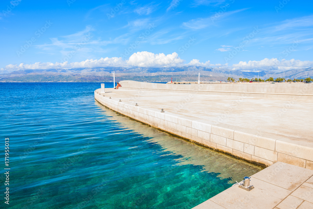 Crystal clear sea in Supetar port with mountains on mainland visible in distance, Brac island, Croatia