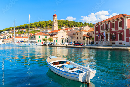 Fishing boat in Pucisca port with beautiful church in background  Brac island  Croatia