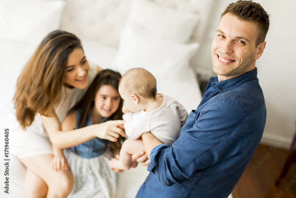 Young parents with daughters in the room