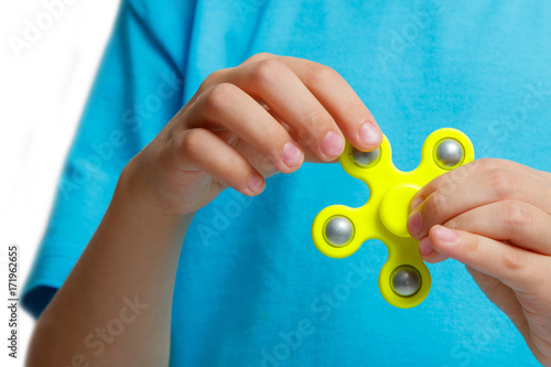 kid hand holding popular fidget spinner toy photo