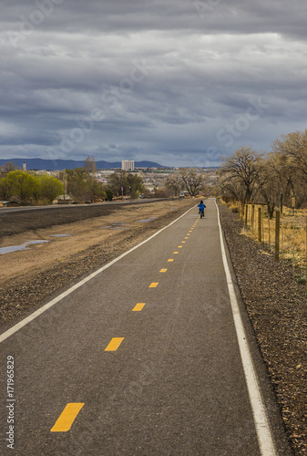 young boy riding a bike along a city trail