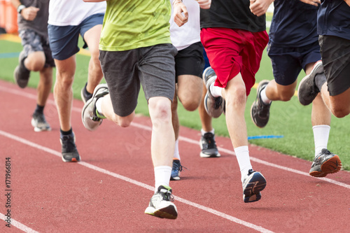 High school boys running in a group on a red track