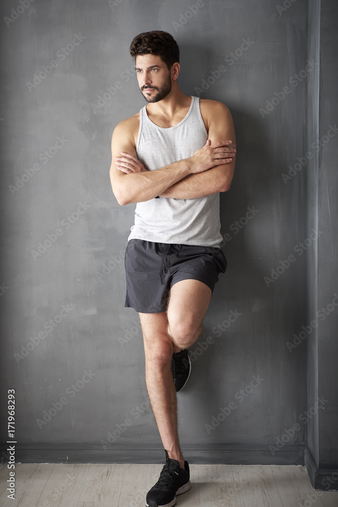 He's always fit. Full length shot of a young man standing with arm crossed in the gym.