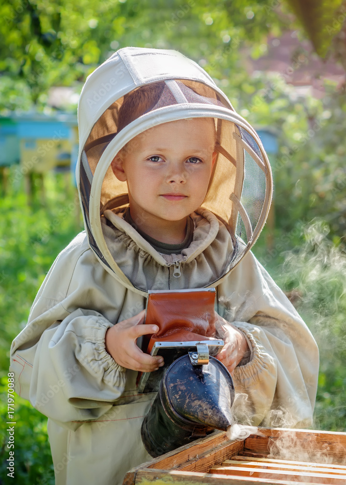 Zdj cie Stock The Boy Beekeeper Works On A Beehive At The Hive Apiary zdj-cie-stock-the-boy-beekeeper-works-on-a-beehive-at-the-hive-apiary