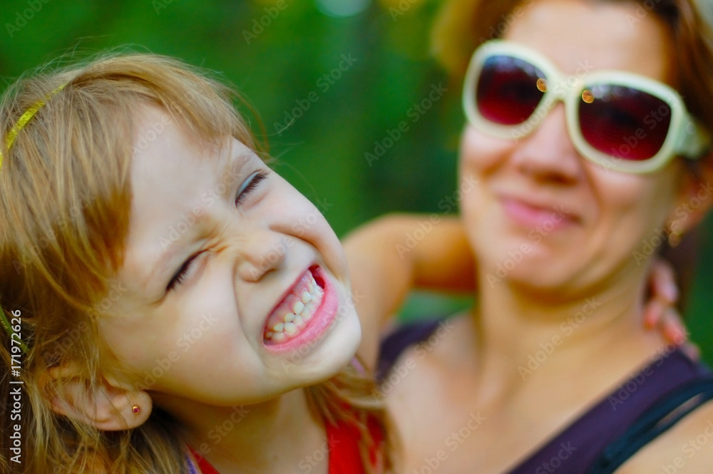 Mom keeps her daughter in her arms. They walk together in the park Mom keeps her daughter in her arms. They walk together in the park