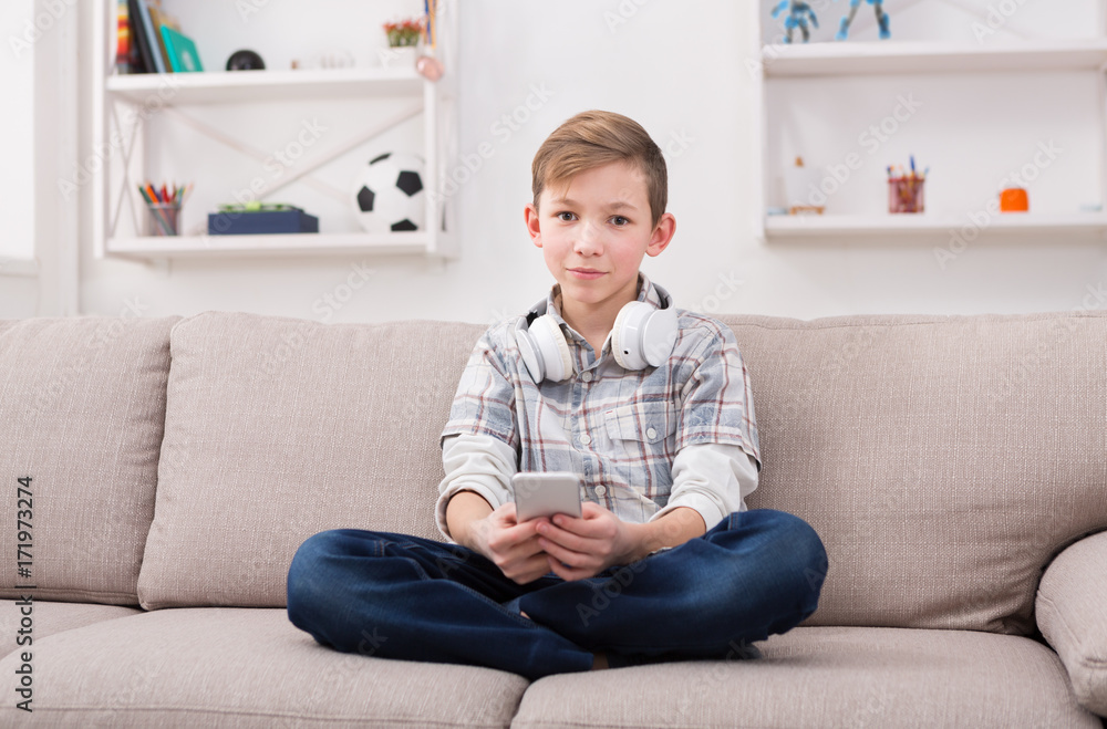 Teenager online on smartphone in living room at home Teenager online on smartphone in living room at home