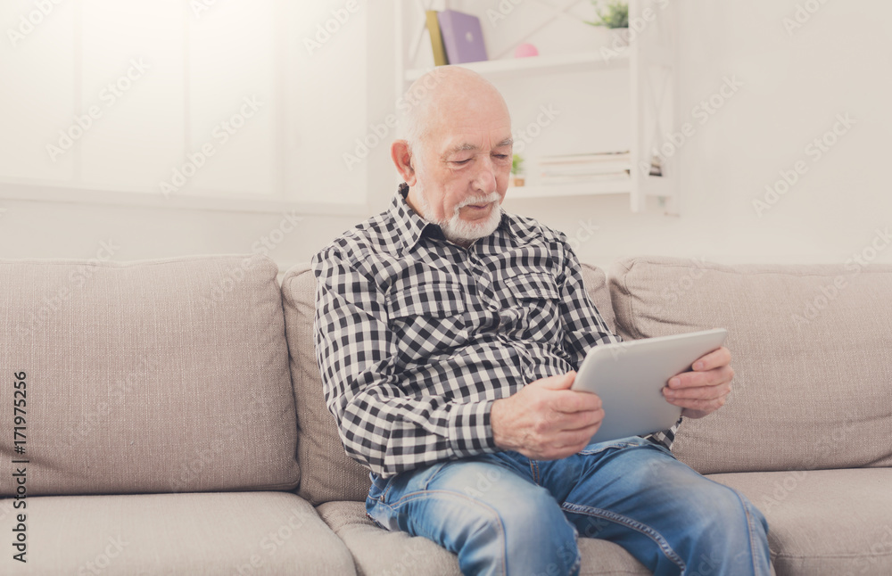 Senior man reading news on digital tablet Senior man reading news on digital tablet