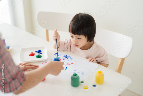 A happy family is painting. Mom help her daughter drawing