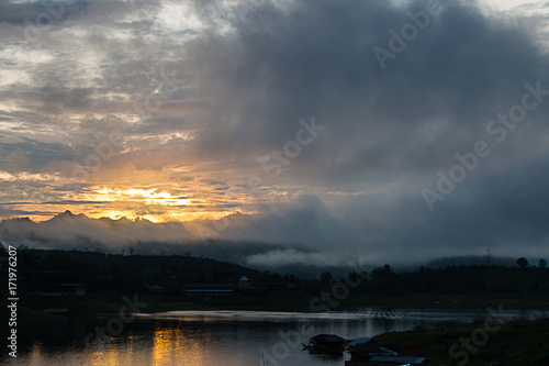 Sunrise on the river with clouds and fog.