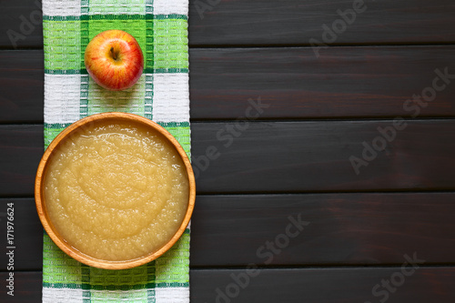 Bild auf Leinwand Homemade apple sauce in wooden bowl, photographed overhead on dark wood with nat