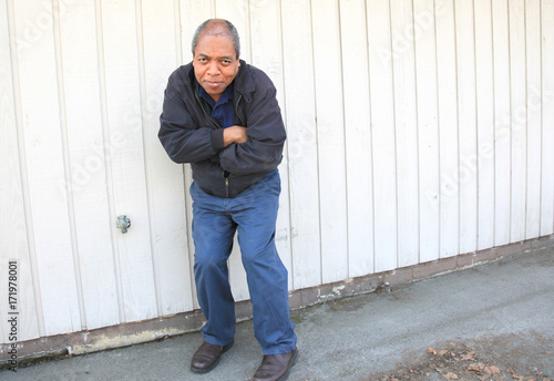 African american male expressions against a wall outside.