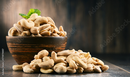 Bowl with cashew nuts on wooden table photo