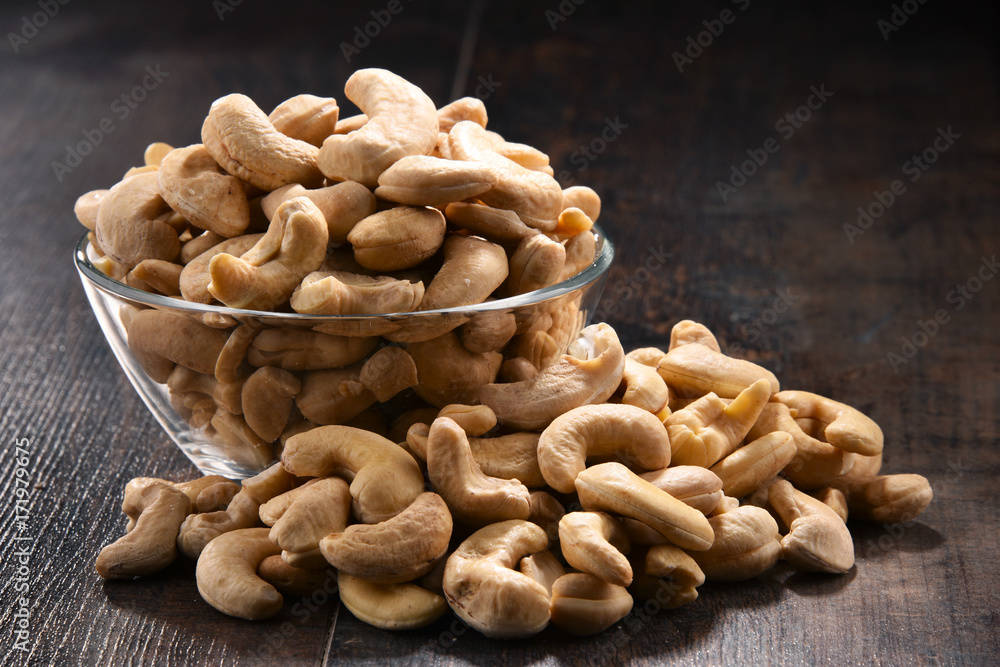 Bowl with cashew nuts on wooden table Bowl with cashew nuts on wooden table