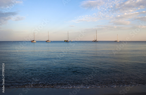 Corsica, 28/08/2017: barche a vela al tramonto sulla spiaggia di Tamarone, una delle più famose e selvagge del Cap Corse