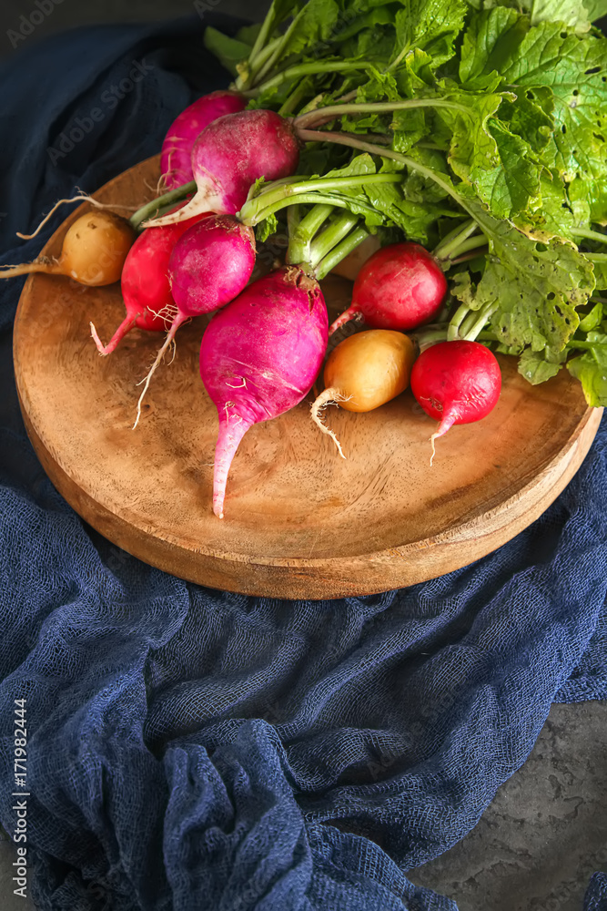 Freshly picked colorful radishes. Growing vegetables. Vegetarian food. Dark background.