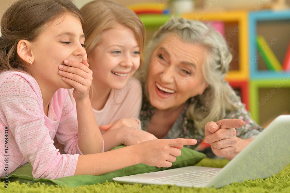 senior woman with granddaughters using laptop senior woman with granddaughters using laptop