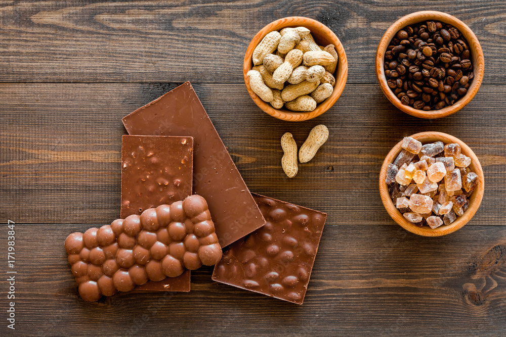 Fototapeta premium Chocolate with nuts on dark wooden background top view copyspace