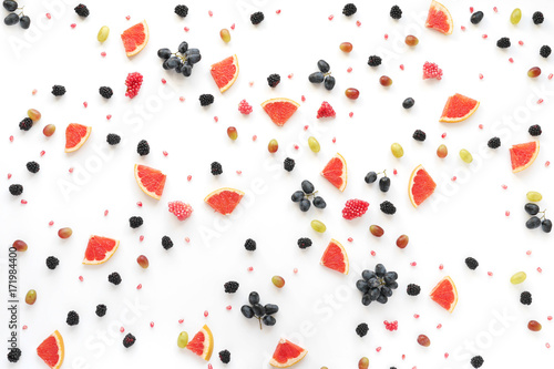 Fototapeta Naklejka Na Ścianę i Meble -  Concept of healthy food. Berries and fruit pattern. Blackberries, grains of pomegranate, black and green grapes on a white background.Composition of berries and fruits, top view.
