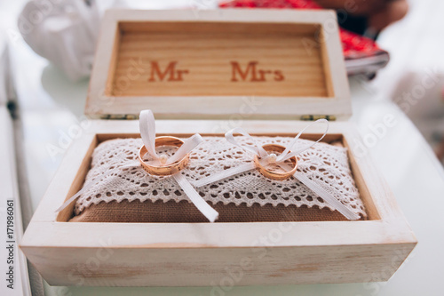 golden wedding rings in a white wooden box. Wedding decoration. Symbol of family, unity and love © ig_royal
