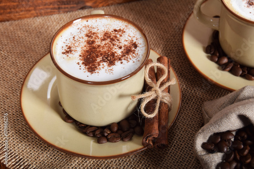 Fototapeta Naklejka Na Ścianę i Meble -  coffee with milk and chocolate foam in brown ceramic cups with vanilla and coffee grains