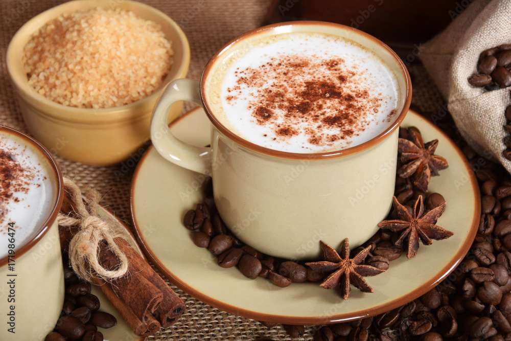 coffee with milk and chocolate foam in brown ceramic cups with vanilla and coffee grains coffee with milk and chocolate foam in brown ceramic cups with vanilla and coffee grains