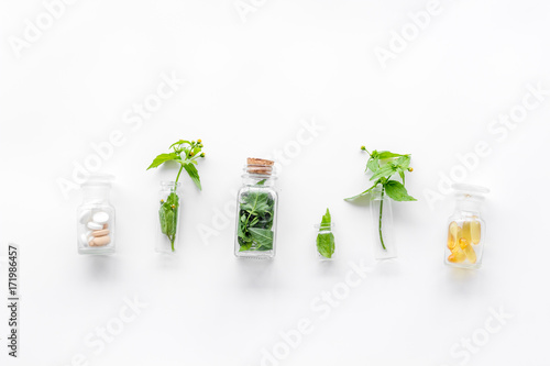 Fotografie Medicinal herb in bottles on white background top view copyspace