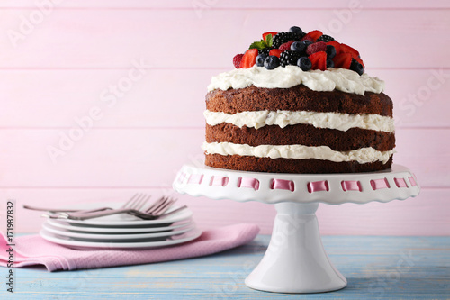 Delicious chocolate biscuit cake with berries on cake stand