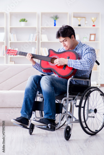 Disabled man playing guitar at home