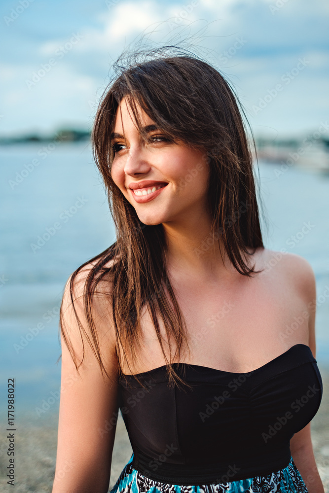 Beautiful brunette girl smiling at the beach