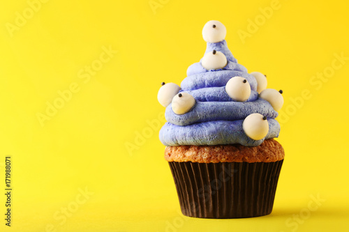 Halloween cupcake on yellow background