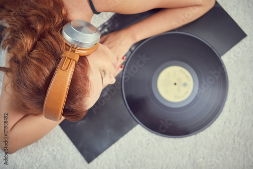 Woman listening vinyl at home. Evening atmosphere photo