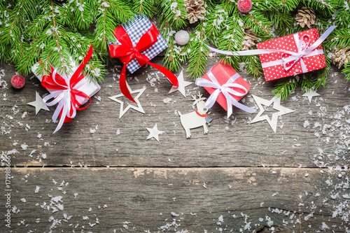 New Year and Christmas background on an old gray wooden background. View from above. Christmas tree branches and snow, gifts and decorations.