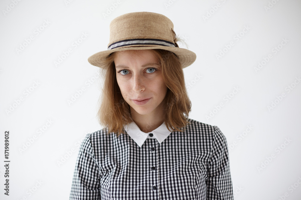 Human facial expressions and emotions. Horizontal studio portrait of beautiful young lady with freckled skin and sad blue eyes wearing retro collar dress and round straw hat, having unappy look Human facial expressions and emotions. Horizontal studio portrait of beautiful young lady with freckled skin and sad blue eyes wearing retro collar dress and round straw hat, having unappy look
