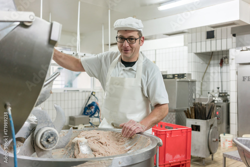 Work in the butchery - butcher grinding meat to make sausages