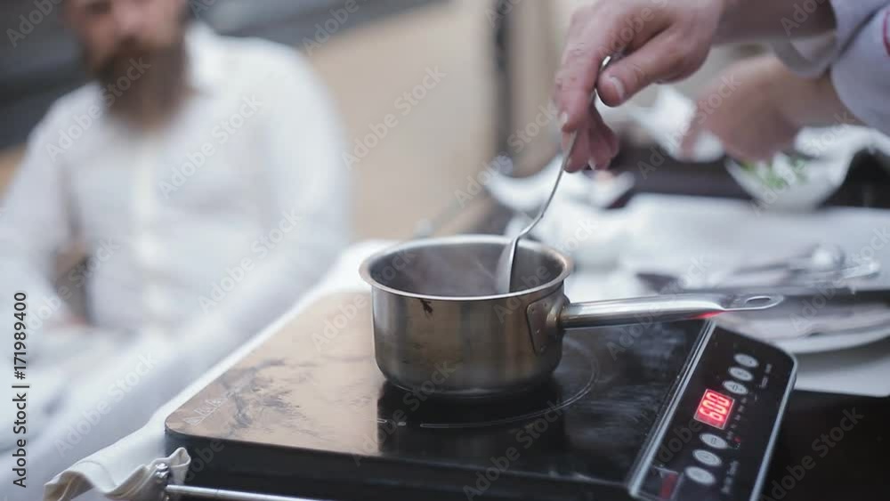 Preparation of a sauce for foie gras in a saucepan on a summer ground of a meat restaurant Preparation of a sauce for foie gras in a saucepan on a summer ground of a meat restaurant