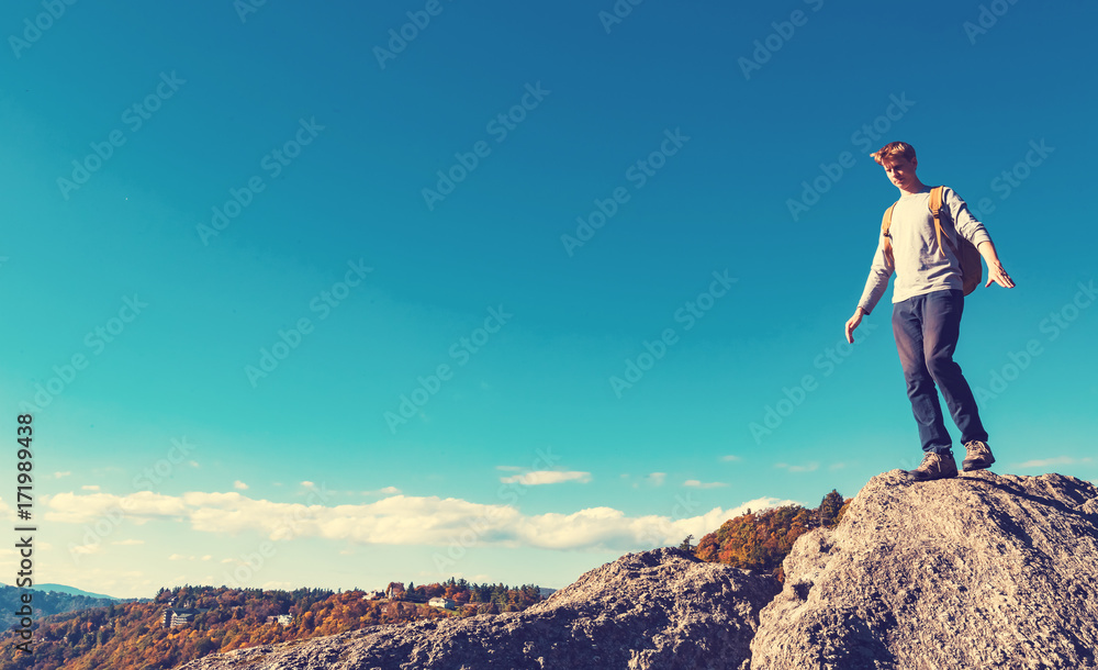 Man walking on the edge of a cliff high above the mountains
Man walking on the edge of a cliff high above the mountains