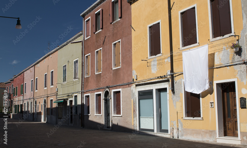 A street with different-coloured houses in Murano, Italy