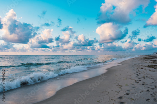white clouds and blue sky over the ocean on a summer morning at the beach