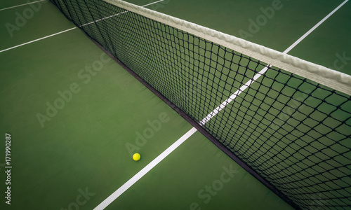 tennis ball near the net on hard court